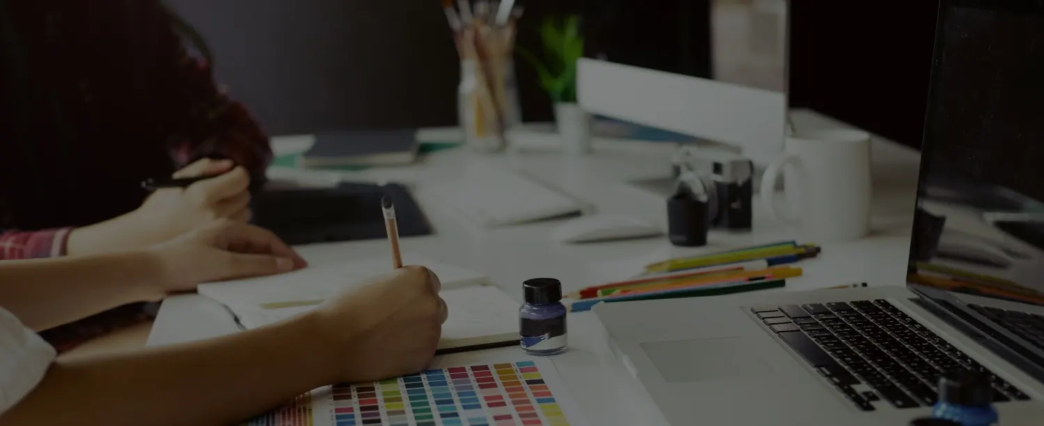 Mesa de trabalho do escritório de design com cartela de cores, lápis e notebook